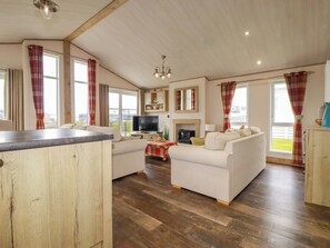 A spacious living area with a sofa set, a television, and a fireplace. - 8 Summerleaze (Bude)