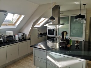 A modern kitchen with skylights, a central island, and a large window. - Bail Mobilit Grand Loft Hypercentre de Lille (Lille)