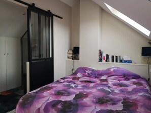 A bedroom with a bed, a wardrobe, a desk with books, and a TV. - Bail Mobilit Grand Loft Hypercentre de Lille (Lille)