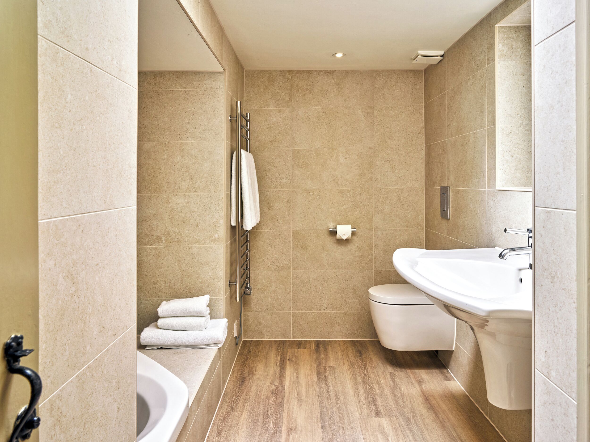 Un baño moderno con bañera, inodoro y lavamanos.