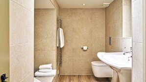 Un baño moderno con bañera, inodoro y lavamanos.