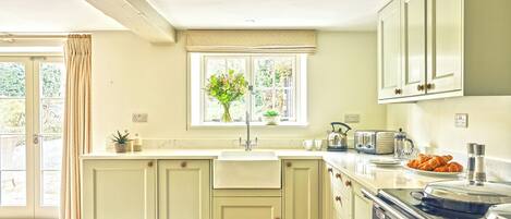 A kitchen with a large island, a window with a view, and a vintage stove.