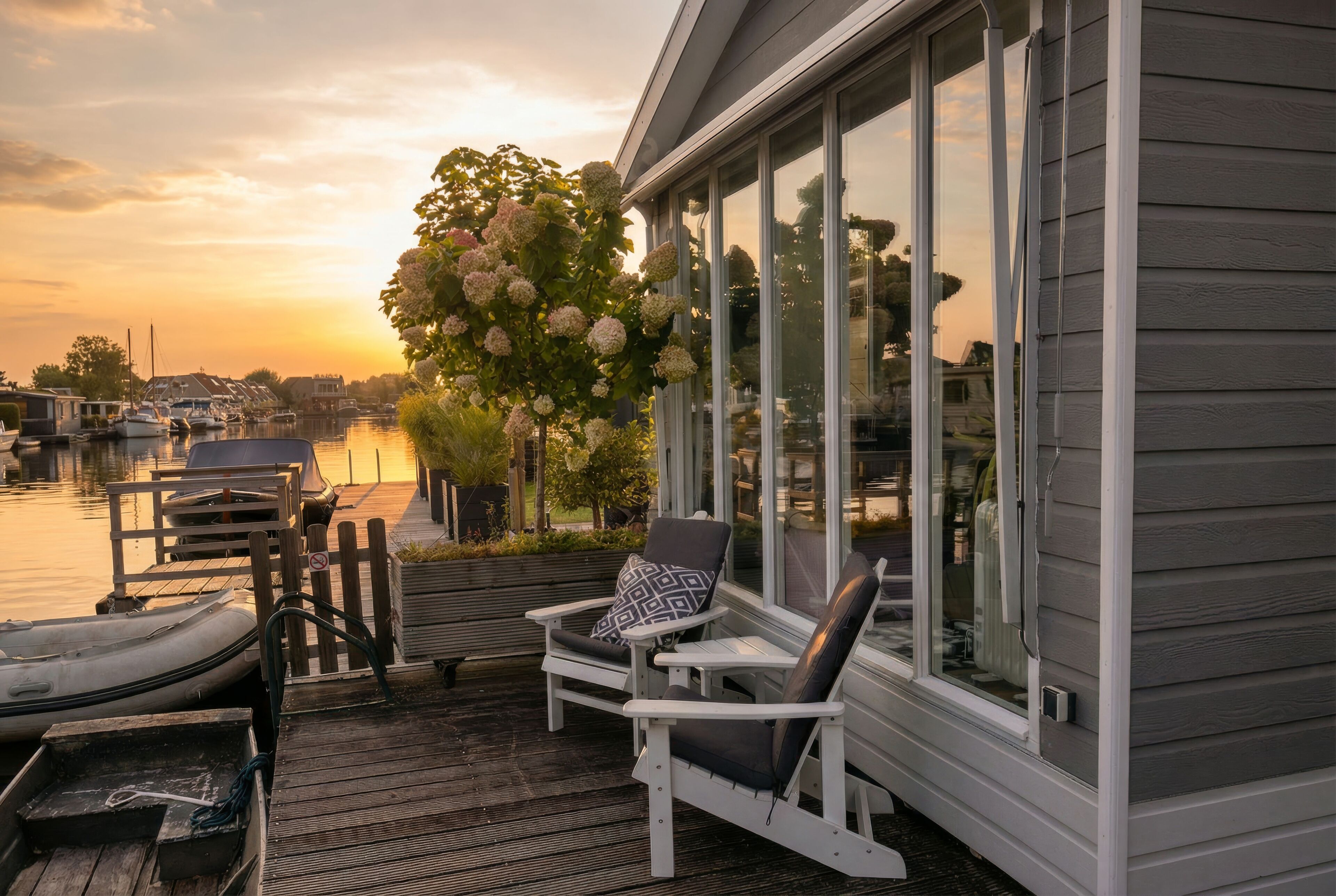 Ein Ufergrundstück mit Steg, Stuhl und großem Fenster mit Blick auf das Wasser.