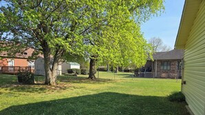 A residential backyard with a lawn, a tree, and a house. - This cozy 3 bed 2 bath house will remind you of a weekend at Grandmother's. (Albertville)
