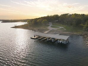 A docked boat with a covered structure, surrounded by water and trees.