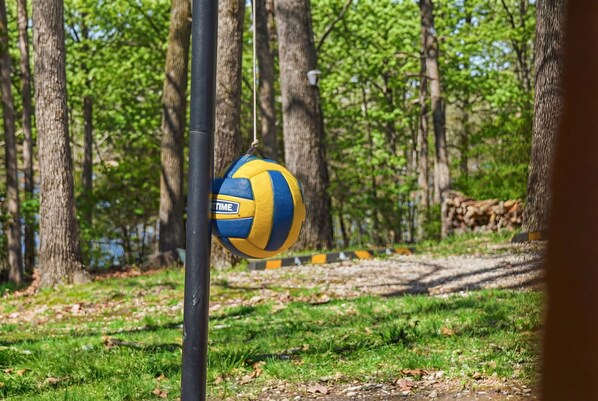 Un ballon de volley-ball suspendu à un poteau dans une zone boisée.