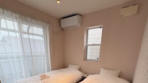 A hotel room with two beds, a window, an air conditioning unit, and a ceiling light fixture. - Perfect Base for Families - 3Bedrooms, 2Baths, Full-Kitchen, Free-P (大阪市)