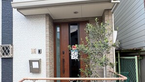 A modern building with a tiled entrance, a wooden door, and a small tree in the foreground. - Perfect Base for Families - 3Bedrooms, 2Baths, Full-Kitchen, Free-P (大阪市)