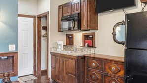 A kitchen with wooden cabinets, a microwave, a coffee maker, and a black refrigerator. - Quail Cove 6 Lakefront Studio Boat Slip Optional (Shell Knob)