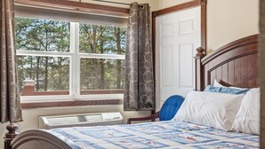 A bedroom with a bed, a window with curtains, a radiator, and a view of trees. - Quail Cove 6 Lakefront Studio Boat Slip Optional (Shell Knob)