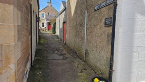 A narrow alleyway with a sign for 'MOAT COTTAGES' and a directional arrow.