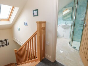 A staircase leading to a bathroom with a glass shower enclosure and a skylight above. - Millmead House Annex (Weymouth)