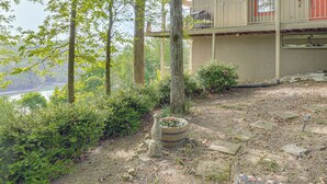 A multi-story building with a balcony, surrounded by trees and a garden area with a wooden planter. - Getaway 1 Mi to Sligo Marina & Center Hill Lake! (Smithville)