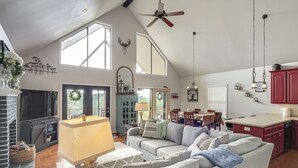 A spacious living room with a fireplace, a ceiling fan, and a dining area with a view. - Getaway 1 Mi to Sligo Marina & Center Hill Lake! (Smithville)