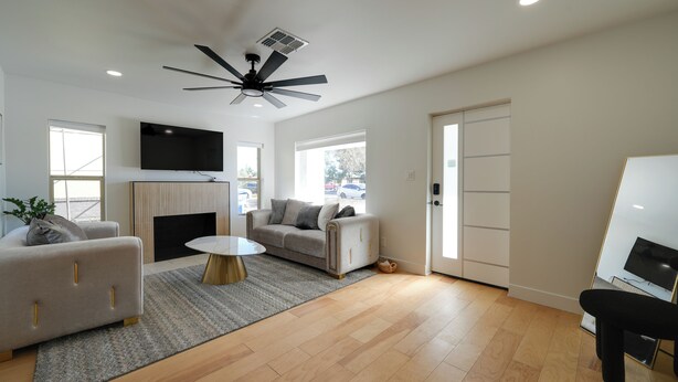 A modern living room with a sofa, a coffee table, a TV, and a ceiling fan. - 3 Mi to Dtwn! Family & Pet-friendly Gem in Phoenix (Phoenix)