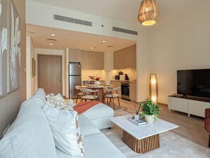 Un appartement moderne comprenant un salon, un coin repas, une cuisine et un téléviseur.