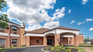 A multi-story building with a brick facade, large windows, and a central entrance with an archway.