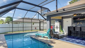 A swimming pool with a covered area, lounge chairs, and a patio with outdoor furniture. - Patio & Poolside Relaxation! Palm Coast Getaway (Palm Coast)