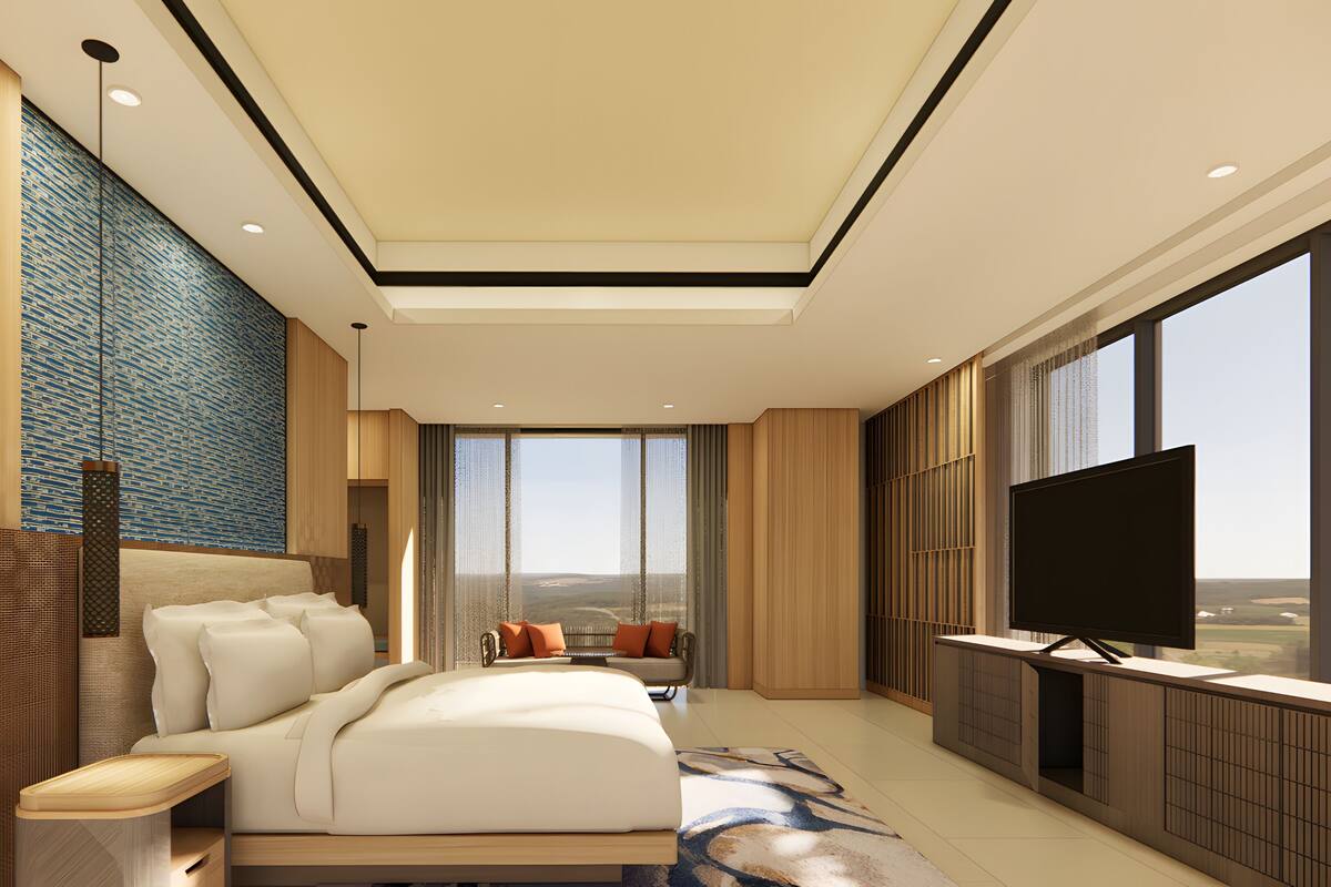 A modern hotel room with a large bed, a TV, and a view of the landscape.
