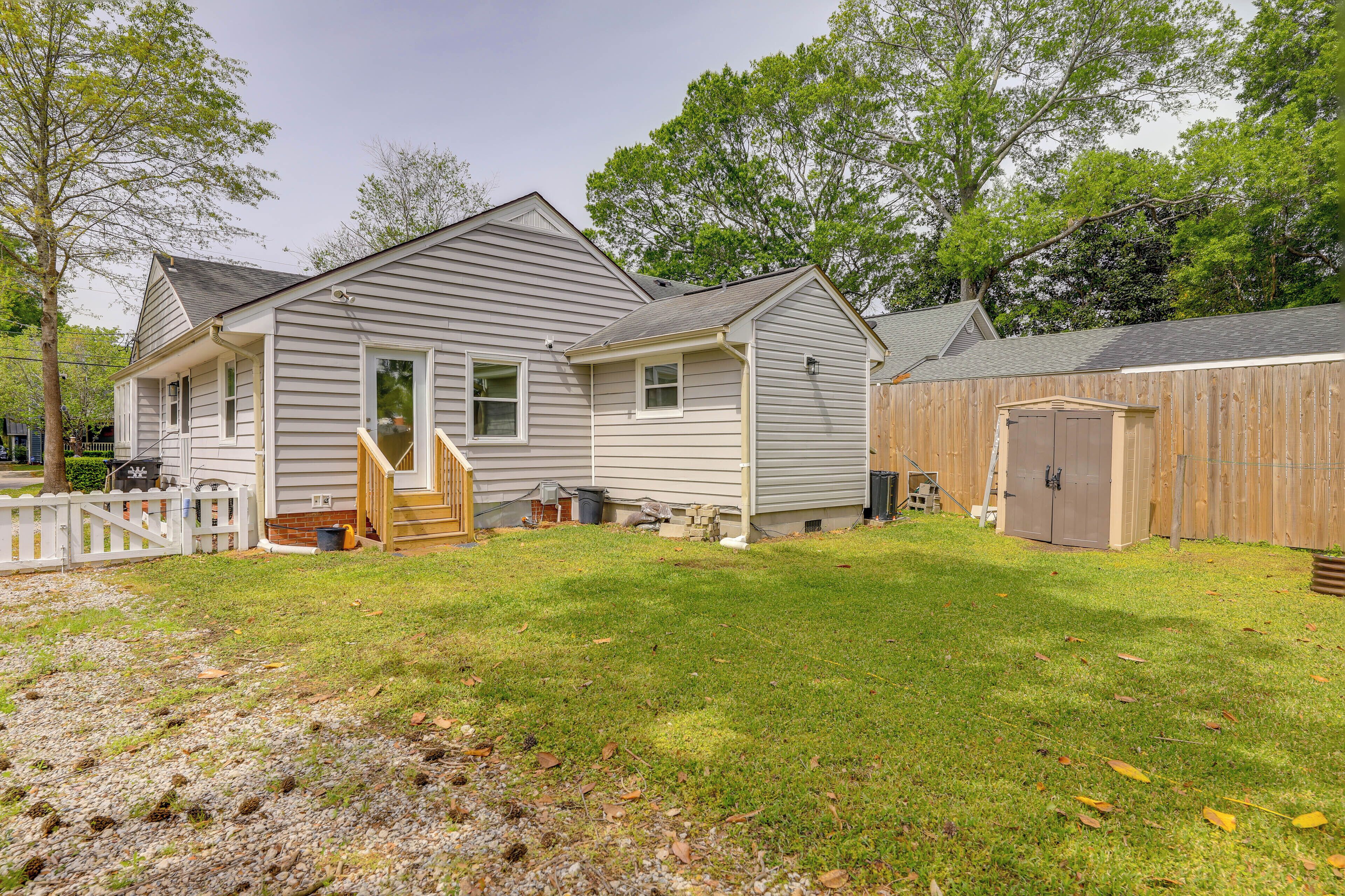 A two-story house with a front porch, a wooden shed, and a well-maintained lawn.