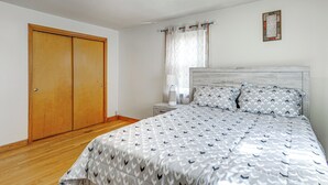 A bedroom with a bed, a nightstand, a wooden wardrobe, and a window with curtains. - Walk to Shops & Eats! Attleboro Basecamp (Attleboro)