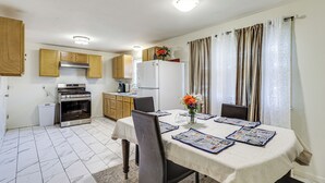 A compact kitchen with wooden cabinets, a white refrigerator, and a stove. - Walk to Shops & Eats! Attleboro Basecamp (Attleboro)