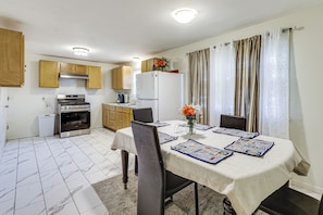 A compact kitchen with wooden cabinets, a white refrigerator, and a stove. - Walk to Shops & Eats! Attleboro Basecamp (Attleboro)