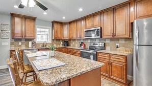 A kitchen with wooden cabinets, a granite countertop, stainless steel appliances, and a ceiling fan. - 3 Mi to Nolin Lake Boat Ramp! Family Home w/ Deck (Mammoth Cave)