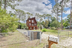 A two-story wooden house with a fenced yard, a mailbox, and a small shed. - Spacious Home w/ Yard & Patio in Lehigh Acres (Lehigh Acres)