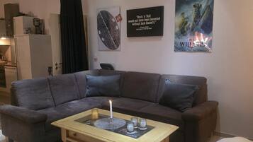 A living room with a sectional sofa, a coffee table, and artwork on the walls.