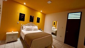Une chambre à coucher avec un lit, une table de chevet et un miroir.