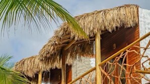 A wooden structure with thatched roofs and a wooden staircase leading to a balcony. - Villa jaguar (Fortim)
