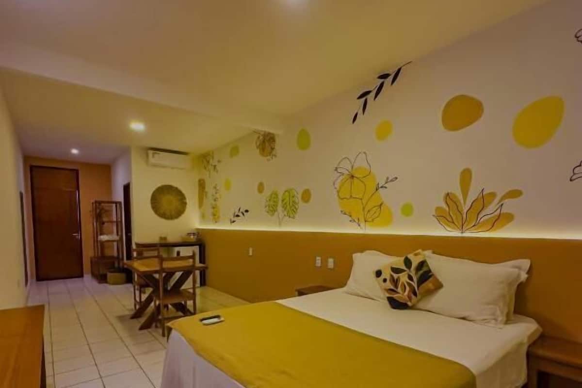 A hotel room with a bed, a desk, and a chair.