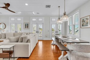 A modern living room with a sofa, dining table, and pendant lights. - 🏠Single Family Home🐶Dog OK🐬Quick/Easy Walk to Beach🌴Casa Solmar (Treasure Island)