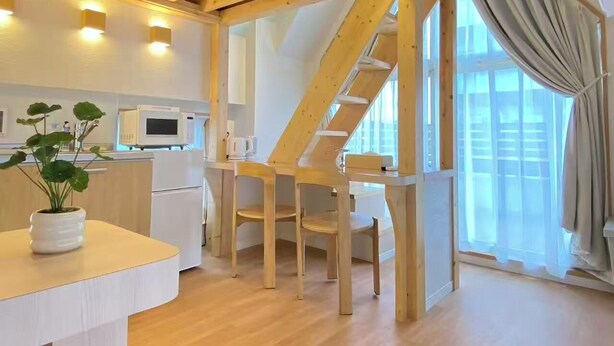 Una cocina moderna con vigas de madera, un refrigerador blanco y un microondas.