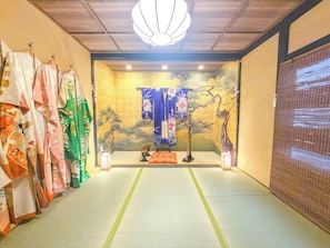 A traditional Japanese room with tatami flooring, a shoji screen, and a hanging shimenawa rope. - 1 minute from Higashiyama Subway Station, 6 minutes from Sanjo Station, 1-minute walk to Gion, a 120-year-old Kyomachiya, within walking distance of Nishiki Market and Yasaka Shrine. (京都市左京区)