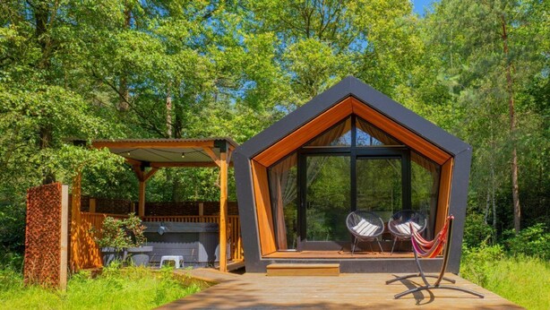 A modern cabin with a large glass window, wooden deck, and two chairs. - Outdoors Holten - Diamond Suite with Jacuzzi (Holten)