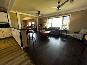 A spacious kitchen with a dining area, a sofa, and a patterned armchair. - Valley View 4BR | Workers, Pets + Space (Valley View)