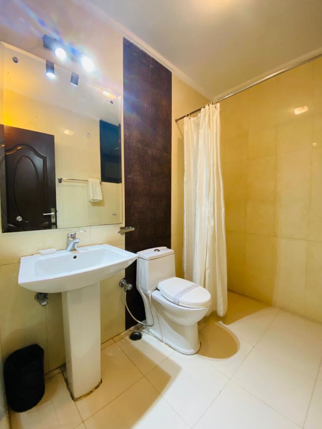 A bathroom with a sink, toilet, and shower curtain.