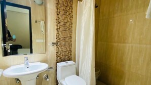 Une salle de bain équipée d’un lavabo, de toilettes et d’un rideau de douche.