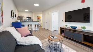 A modern living room with a sofa, coffee table, and TV. - Peaceful ! Free Parking ! 30 min to MetLife ! (City of Orange)