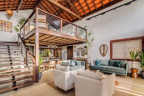 A spacious living area with a wooden staircase, a dining area, and a kitchen. - Casa Melina - 1 5BR Private Beach House in Anjuna (Anjuna)