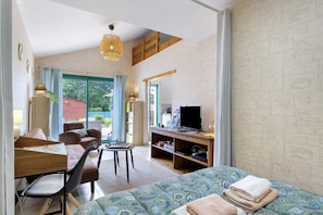 A room with a bed, a desk, a chair, a television, and a bookshelf. - Le Cardoue: Peaceful Gîte Between Land and Sea in the Marais Breton Vendéen (Saint-Gervais)