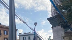 Una calle con coches estacionados, un paso de peatones y edificios con balcones.