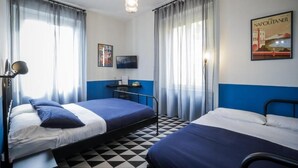 A room with two beds, a desk with a computer, a TV, and a poster on the wall. - Nuccia Urban Loft (Naples)