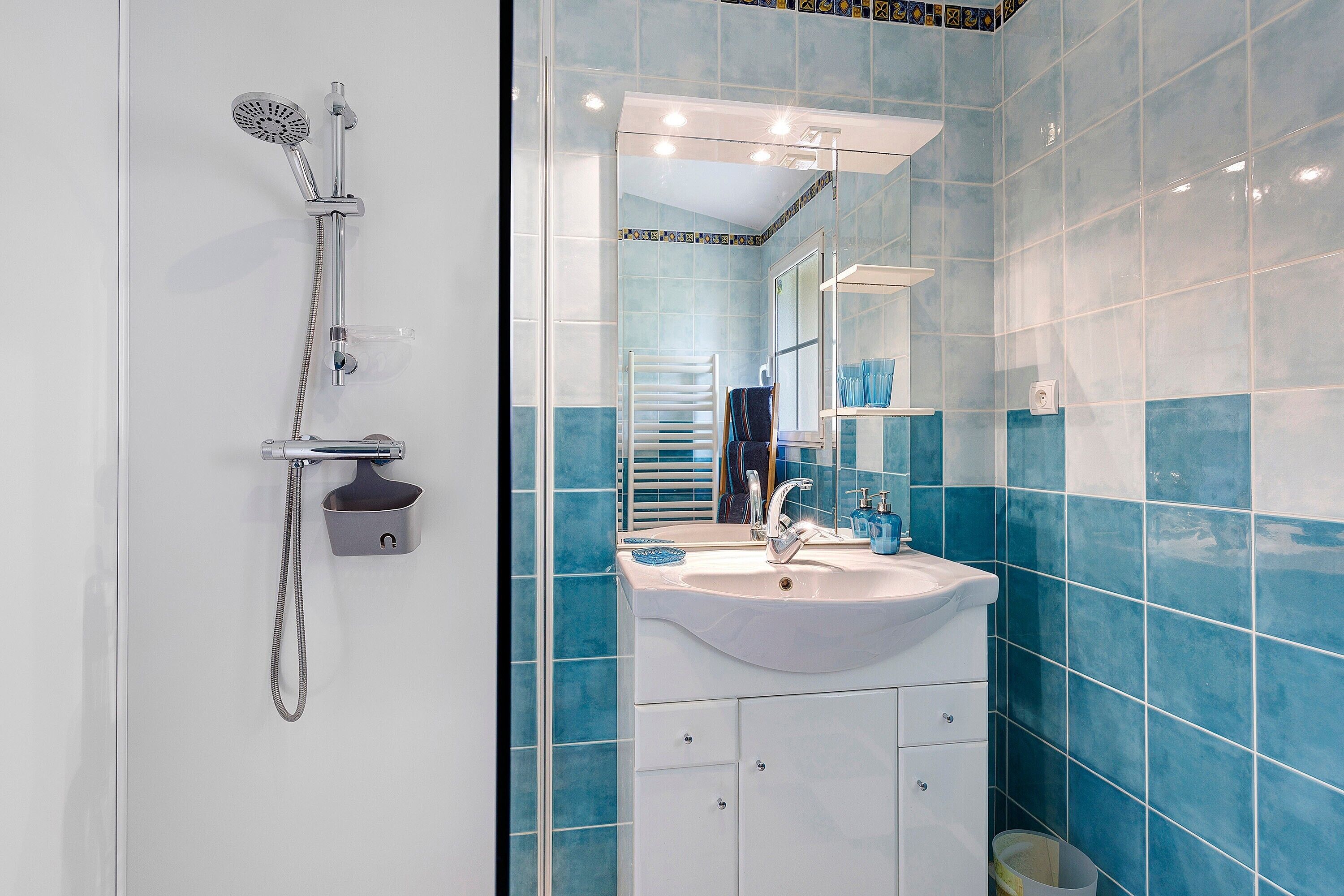 A bathroom with a shower, sink, and mirror.