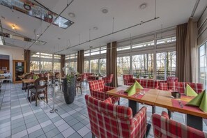 A restaurant with red plaid chairs, large windows, and a tiled floor. - Arnsberg Adventure Starts In Pool Room With Pets Included (Arnsberg)