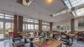 A spacious indoor dining area with multiple tables and chairs, large windows, and a high ceiling. - Modern Room With Pool And Pets Near Neheim Boutiques (Arnsberg)