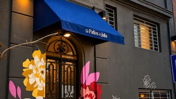 A building facade with a blue awning, large floral decorations, and a sign reading 'Los Patios de Julia'.