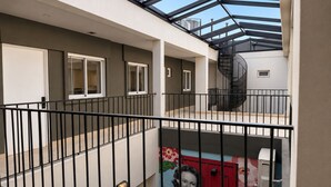 A multi-level residential building with a glass ceiling, a spiral staircase, and a mural on the lower level. - Los Patios de Julia by DOT Boutique (Buenos Aires)